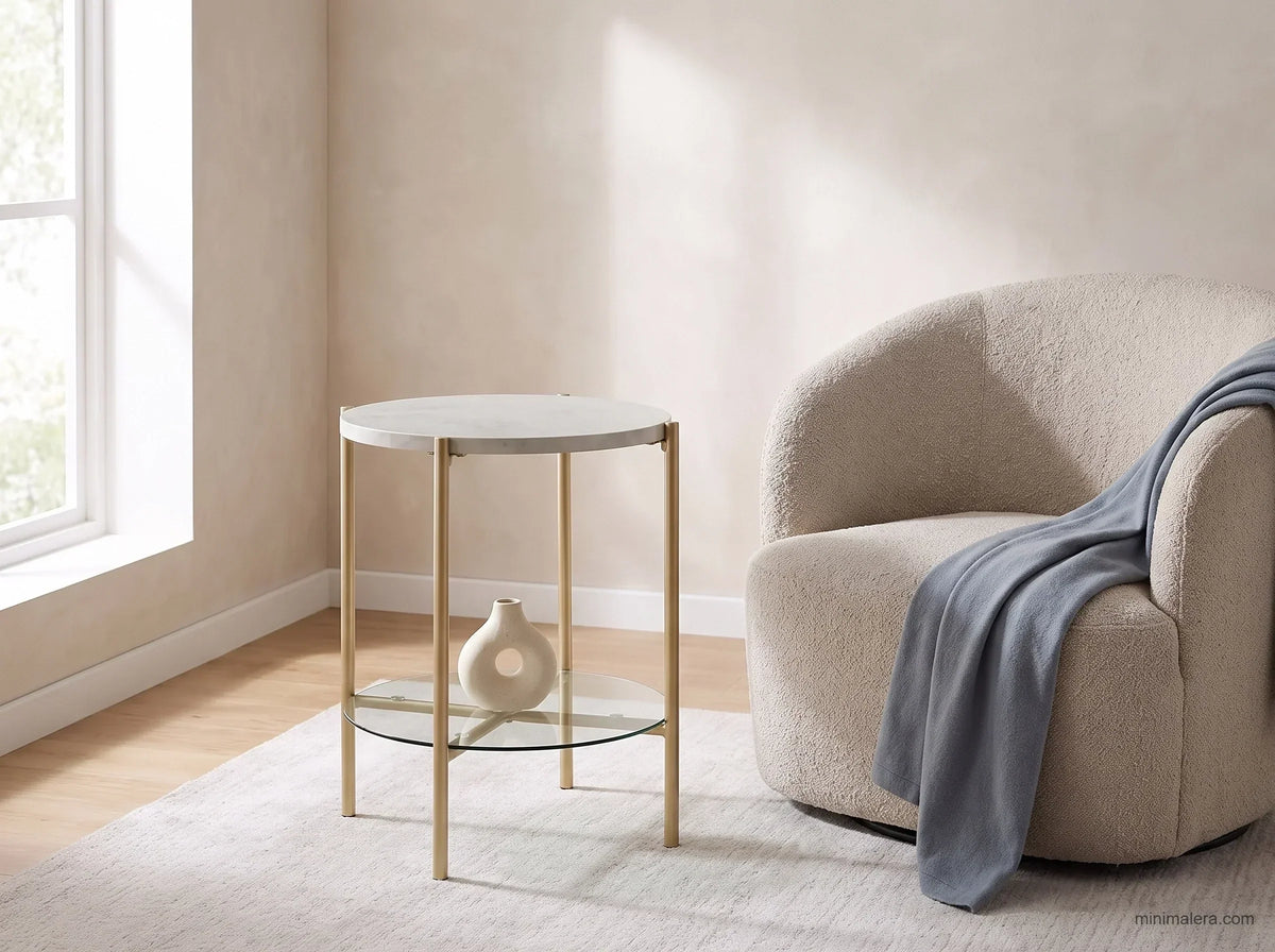 Soft modern living room corner with a round marble-and-gold accent end table beside a curved cream boucle armchair with a dusty blue throw