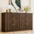 Fluted walnut 6-drawer dresser with gold handles, front view in a bedroom setting
