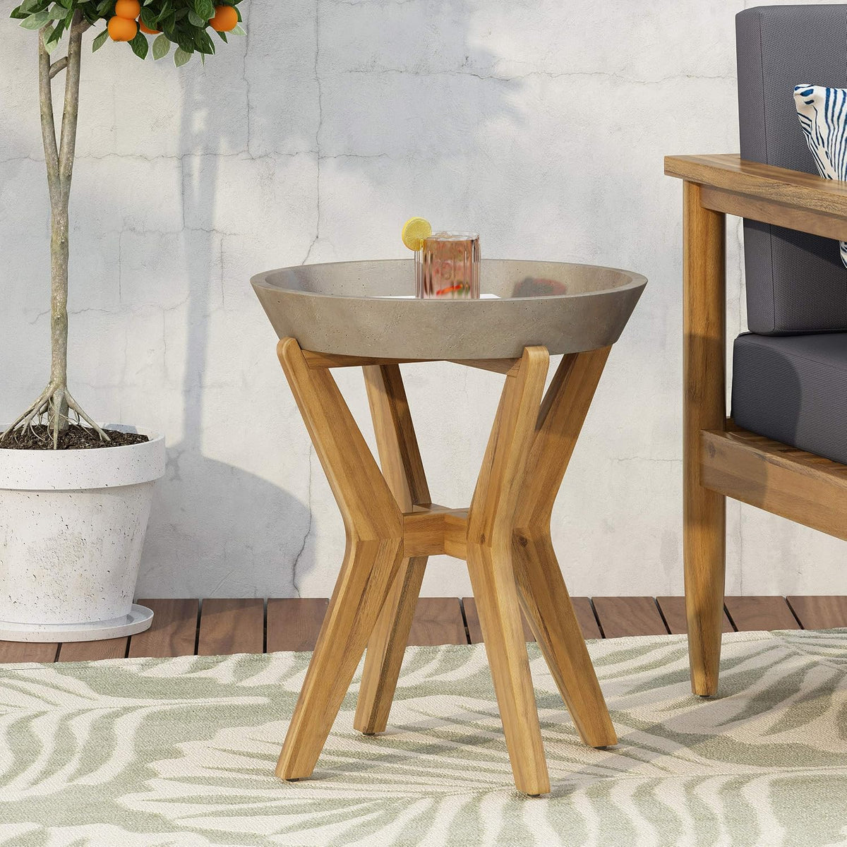 Concrete and acacia wood outdoor side table, angled view showing tripod leg base